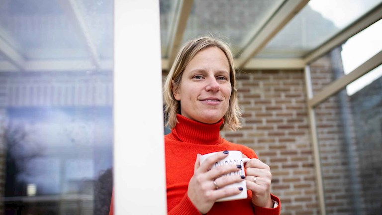 Aurélie avec une tasse de boisson chaude à la main