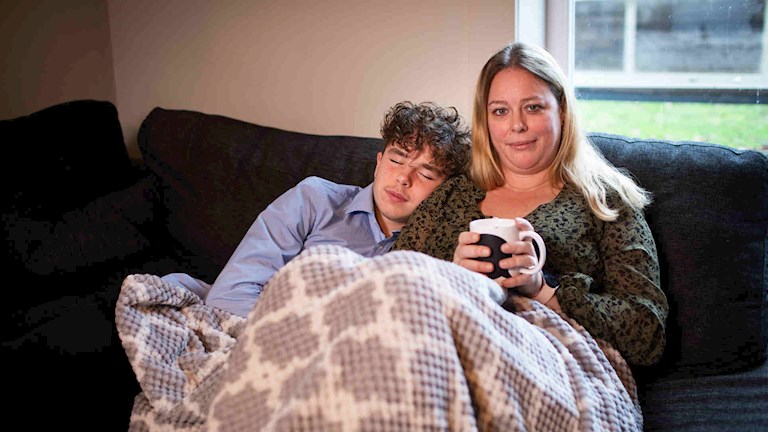Elke met haar zoontje op de bank en een warme deken