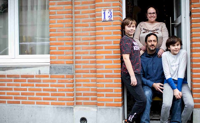 Une photo de David, de sa femme et de ses deux fils devant la porte de leur maison