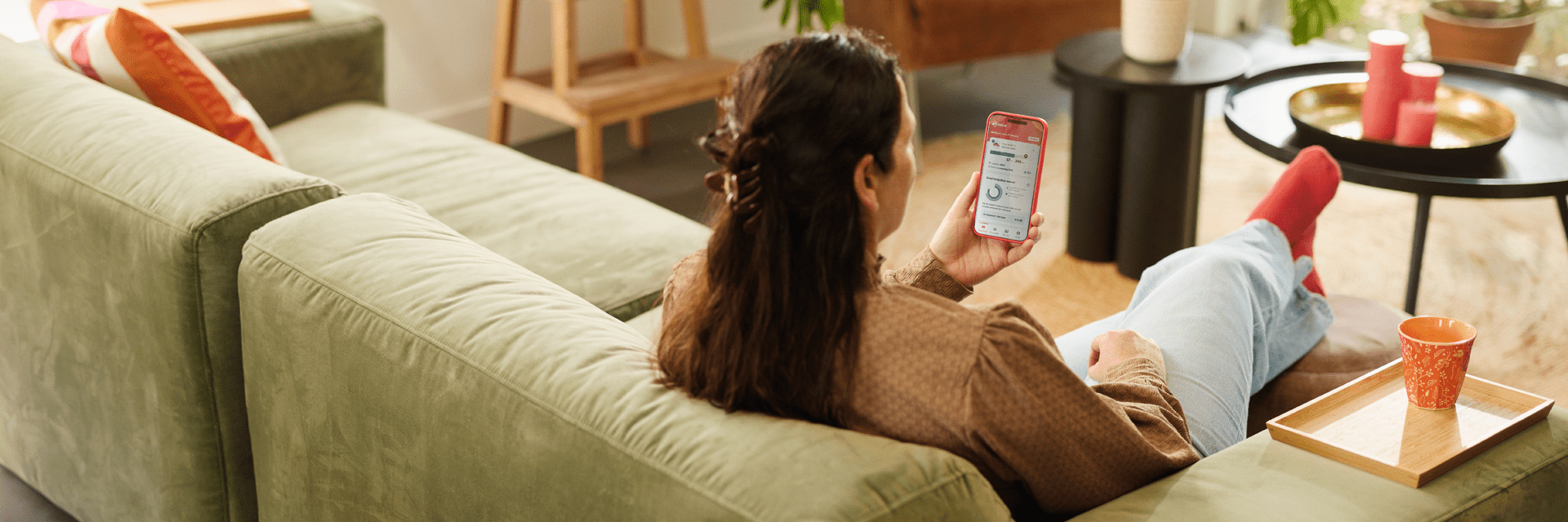 Vrouw op de bank met een telefoon in haar hand