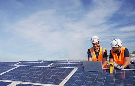 Deux installateurs de panneaux solaires sur le toit