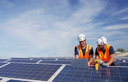 Deux installateurs de panneaux solaires sur le toit