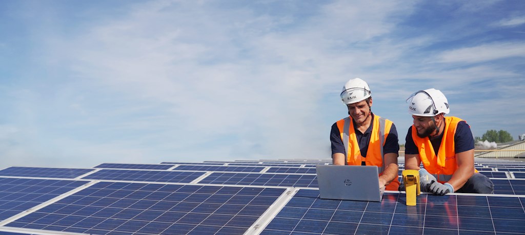 Twee monteurs van zonnepanelen op een dak